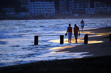 Image showing romantic couple walking on beach at sunset