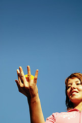 Image showing beautyful girl throwing orange in air