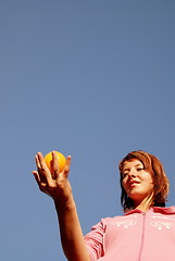 Image showing beautyful girl throwing orange in air