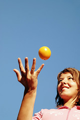 Image showing beautyful girl throwing orange in air