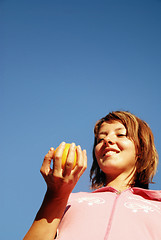 Image showing beautyful girl throwing orange in air