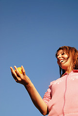 Image showing beautyful girl throwing orange in air