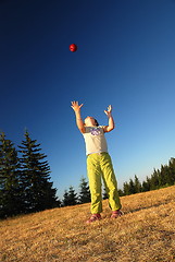 Image showing happy girl throwing apple outside