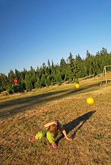 Image showing happy girl throwing apple outside