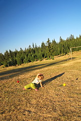 Image showing happy girl throwing apple outside