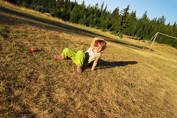 Image showing happy girl throwing apple outside