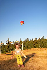 Image showing happy girl throwing apple outside