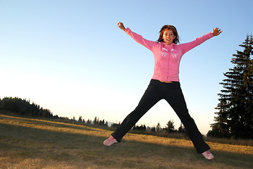 Image showing pretty girl jumping in a air 