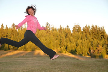 Image showing pretty girl jumping in a air 