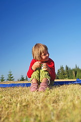 Image showing cute little girl eating healthy food outdoor