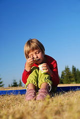 Image showing cute little girl eating healthy food outdoor