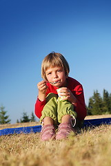 Image showing cute little girl eating healthy food outdoor