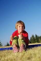 Image showing cute little girl eating healthy food outdoor