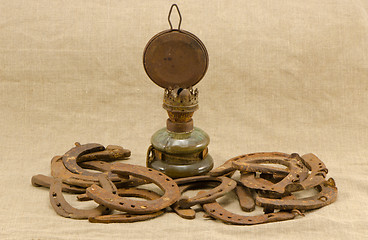 Image showing retro kerosene lamp rusty horse shoes linen 