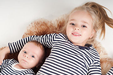 Image showing Newborn baby with sister in striped clothes