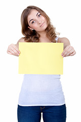 Image showing Beautiful young girl shows a blank sheet of yellow