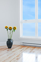 Image showing Sunflowers in empty room with big window