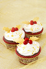 Image showing Christmas cupcakes with gold leaves and red berries