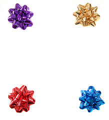 Image showing Four colorful Christmas bows in the four corners of an isolated