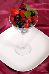 Image showing Fresh berries topped with mint in a martini glass