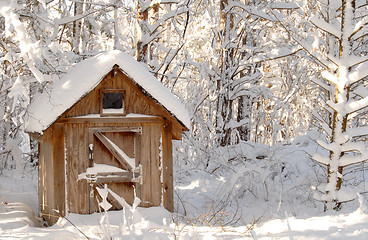 Image showing Snow bound wooden shack in a wooded setting