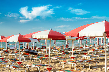 Image showing red and white umbrellas and sunlongers on the sandy beach
