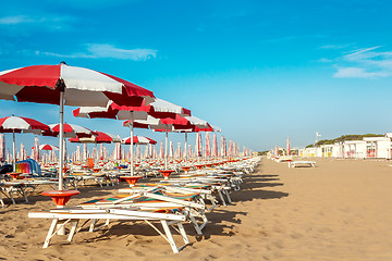 Image showing red and white umbrellas and sunlongers on the sandy beach