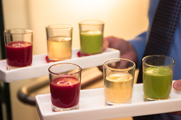 Image showing Servers holding colored shot glasses