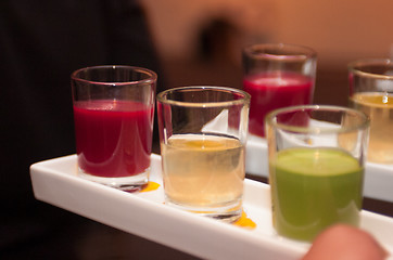 Image showing Servers holding colored shot glasses