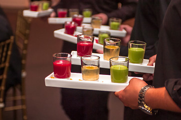 Image showing Servers holding colored shot glasses