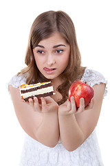 Image showing Girl with apple and cake in hands, closeup portrait