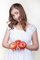 Image showing Girl with three apples in their hands