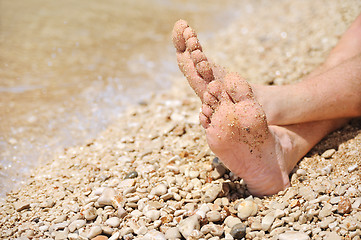 Image showing Relaxation on beach, detail of male feet