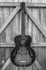 Image showing Monochrome Vintage Acoustic Guitar On Fence