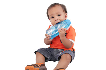 Image showing Adorable one year old child biting bottle and smiling, isolated 