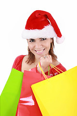 Image showing Happy woman in Santa hat holding shopping bags, over a white bac