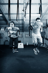 Image showing Young gymnasts training on rings on a dark background