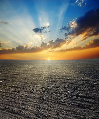 Image showing black ploughed field and sunset