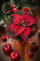 Image showing Christmas flower with decoration on wooden table