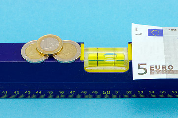 Image showing level tool euro banknote coin on blue 