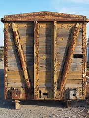 Image showing Back end of abandoned wooden railway car standing on props