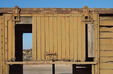 Image showing Detail of a broken door of abandoned wooden railway car 