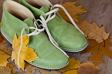 Image showing green leather boots and yellow leaves 