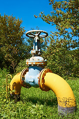 Image showing Gas pipe with a valve on a green lawn
