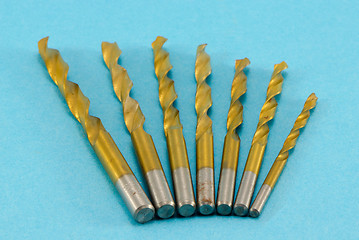 Image showing golden drill bits on blue 