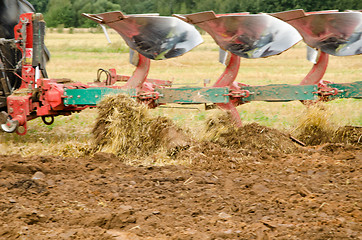 Image showing Closeup tractor plough plowing agricultural field 