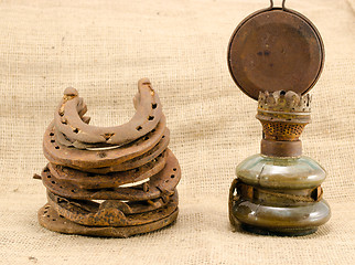 Image showing retro kerosene lamp rusty horse shoes linen 