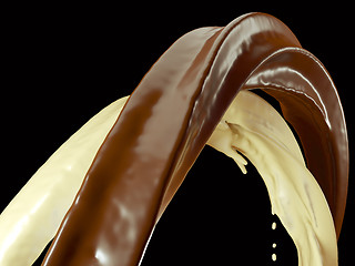Image showing Drinks: Hot dark and milk chocolate flow isolated on black 