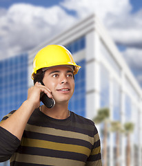 Image showing Hispanic Male Contractor on Phone in Front of Building