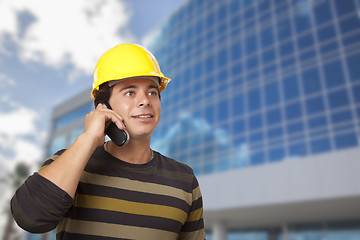 Image showing Hispanic Male Contractor on Phone in Front of Building